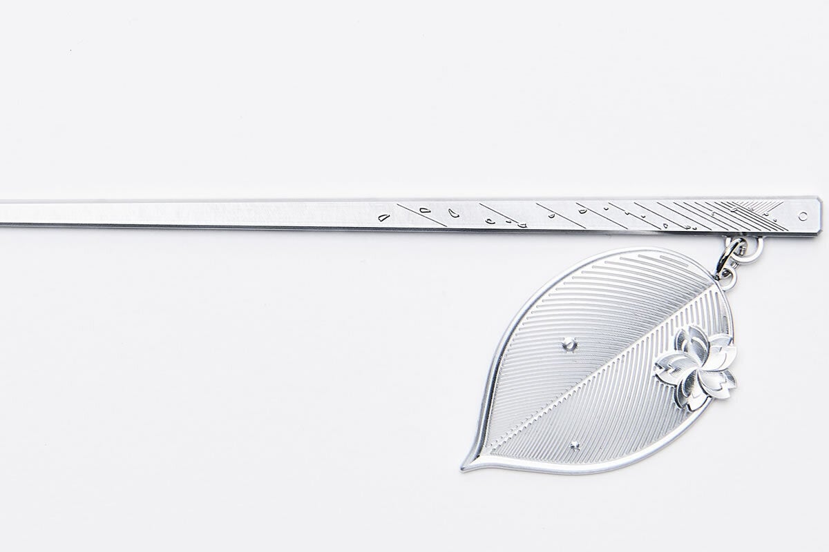 「完全金属削り出し」 の『[cocur] SAKURA（コクール・桜）』  かんざし：しずか本体表面 桜の花びらと静山、太陽に向かって舞う花びらを彫刻