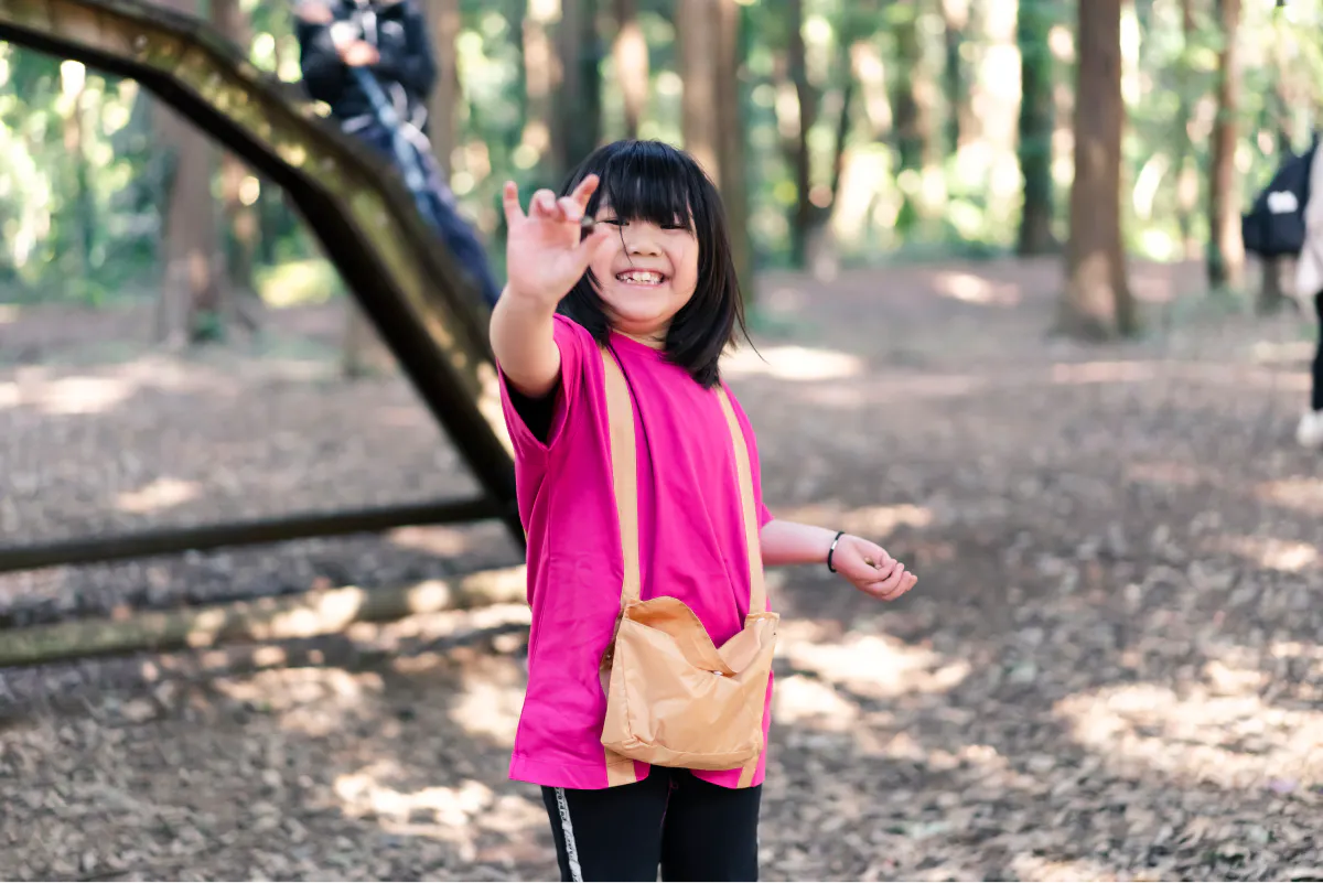 アップサイクルTシャツを着てどんぐり拾いを楽しむ女の子