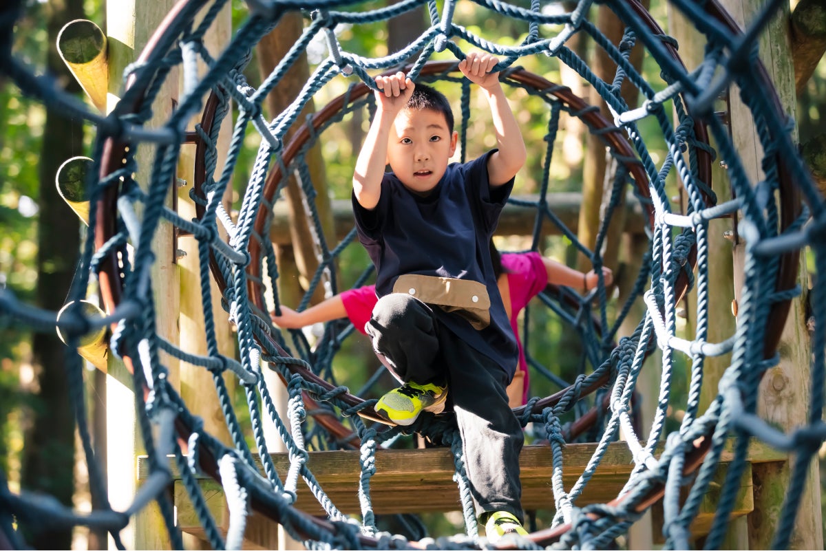アップサイクルTシャツを着て遊具を楽しむ男の子