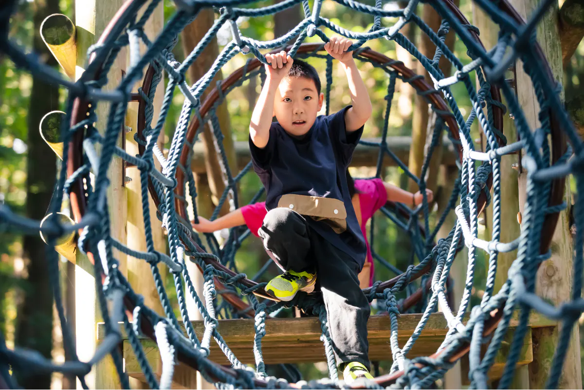 アップサイクルTシャツを着て遊具を楽しむ男の子