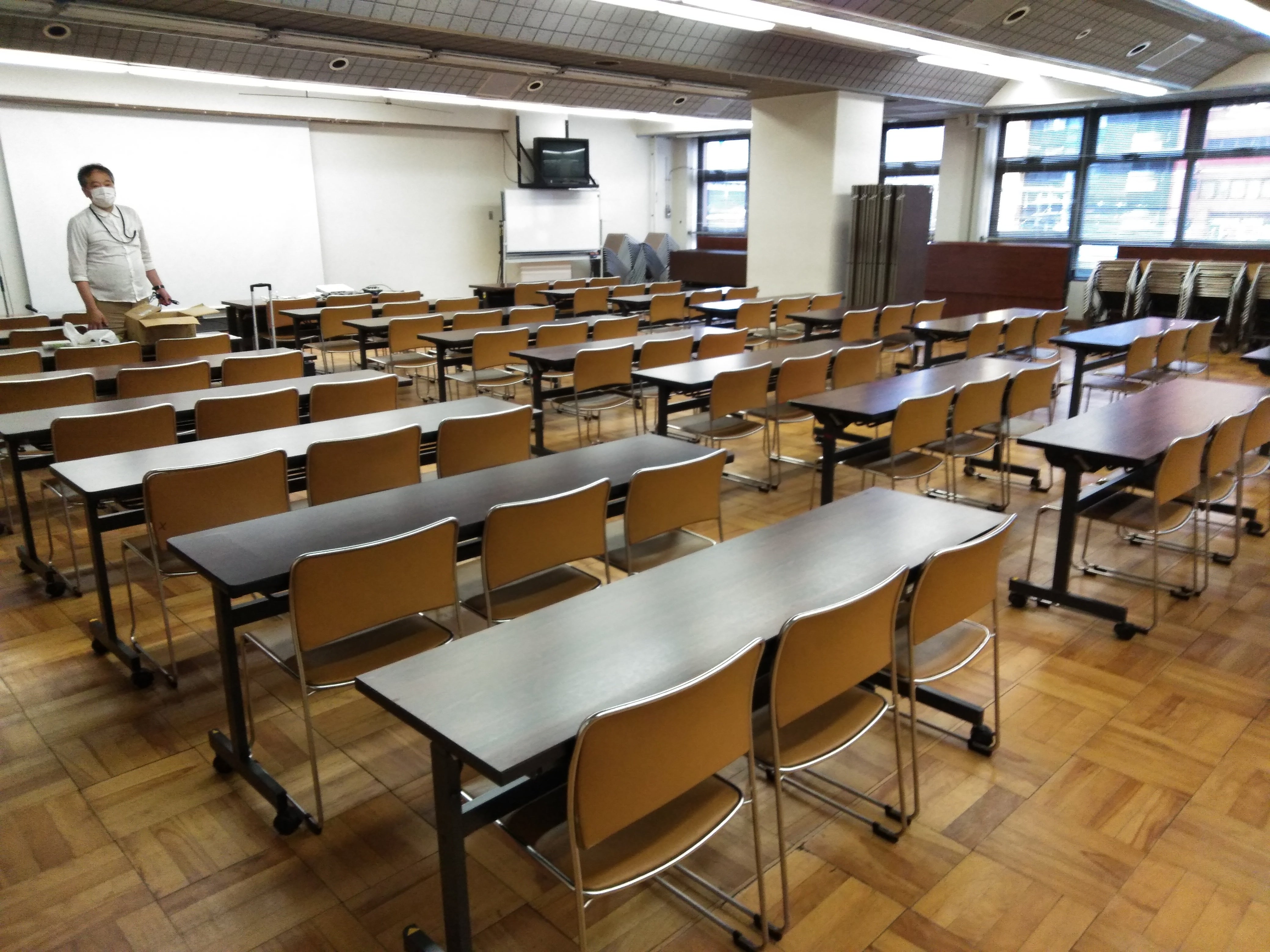 開場前の会場の写真。机といすが並んでいる。大田区消費者生活センター大集会室。