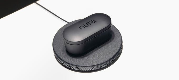 NuraTrue Pro in charging case wirelessly charging on a Qi-certified charging device