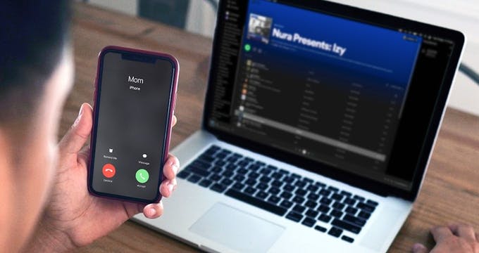 Someone receiving a call while playing music from their laptop