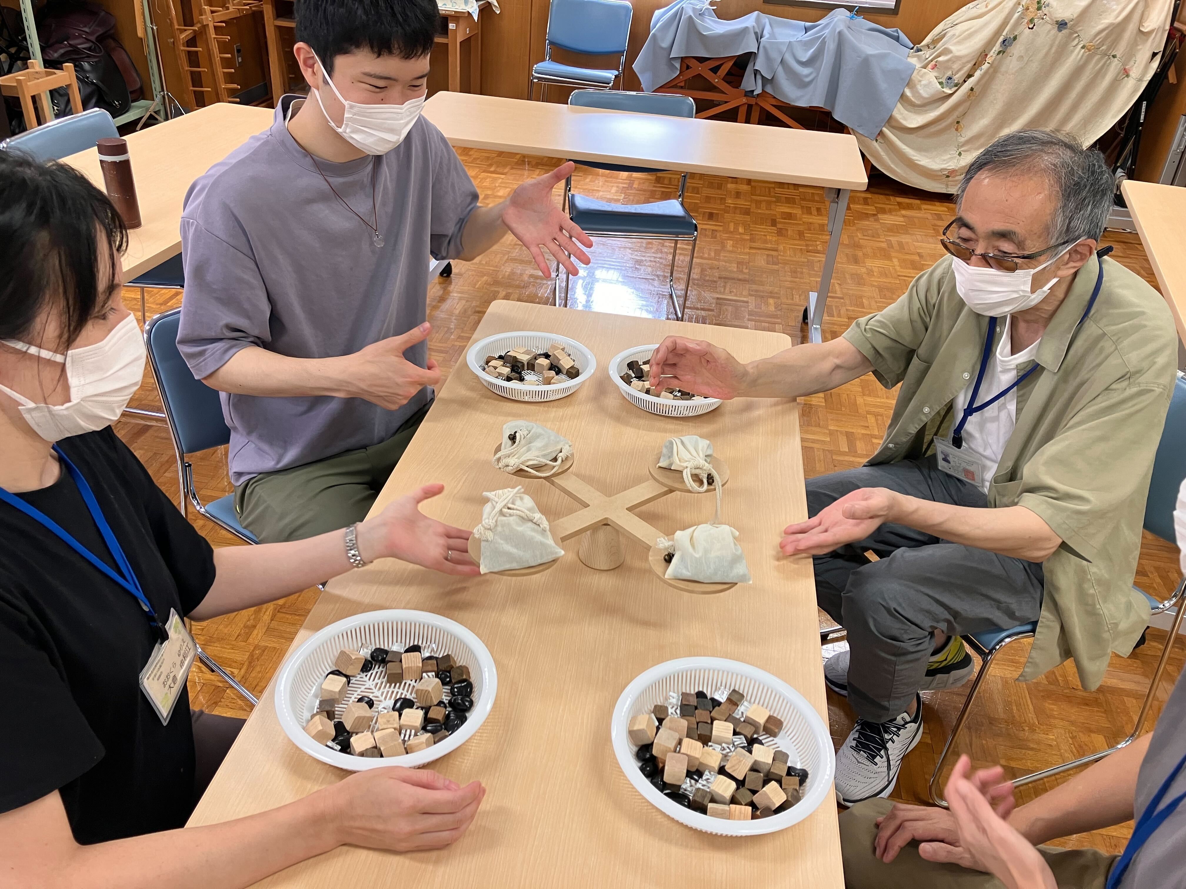天秤が釣り合い、メンバーとすまいる高井戸のみなさんが喜んでいる様子