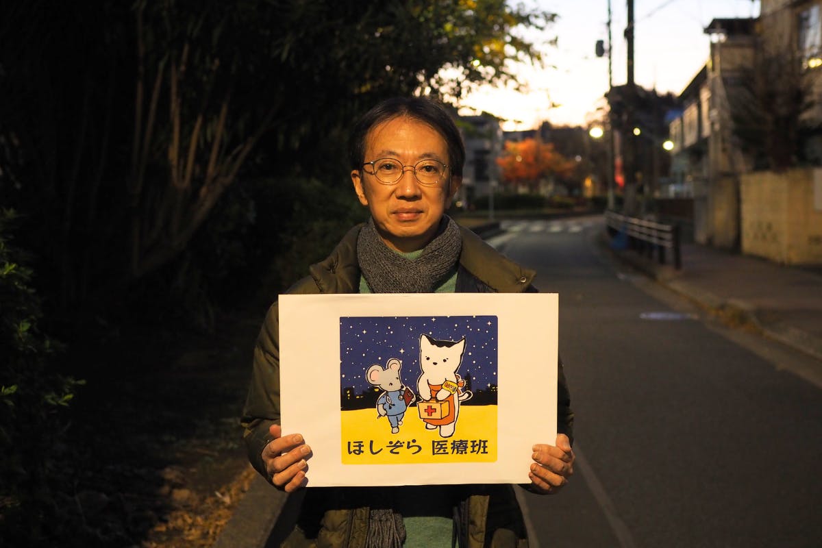 稲葉剛(つくろい東京ファンド代表理事)がほしぞら医療班のロゴを持って写真に写っている。