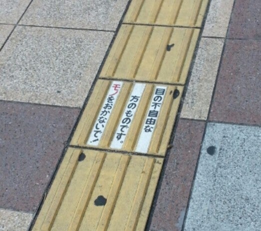 ステッカーが貼られた点字ブロック