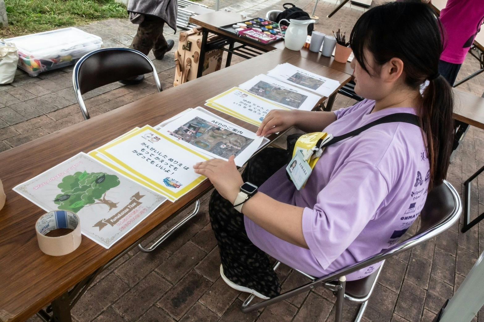 ぬりえコーナーのサイン版を整理するDAKARAちゃん