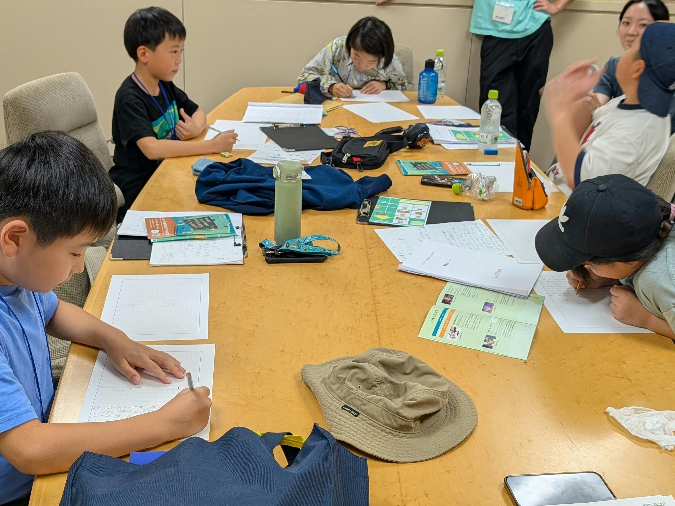 子ども審査員が審査会議を行い講評の作文を書いている様子